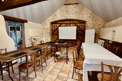 Miniature Petite salle séminaire Chambre mansardée avec lit double, bureau en bois, malles anciennes et murs en pierre apparente.