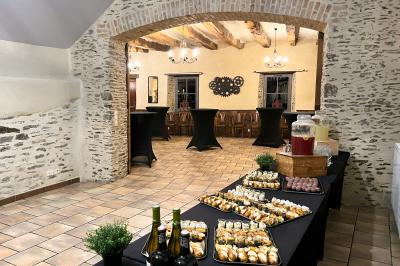 Miniature Salle séminaire cocktail dînatoire Chambre mansardée avec lit double, bureau en bois, malles anciennes et murs en pierre apparente.