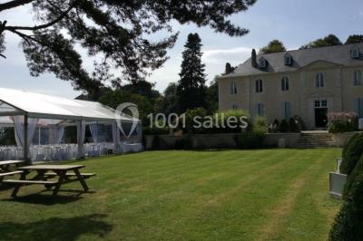 Escalier en pierre décoré de fleurs, menant à une pièce lumineuse avec carrelage en damier et vue sur un jardin.