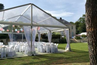 Escalier en pierre décoré de fleurs, menant à une pièce lumineuse avec carrelage en damier et vue sur un jardin.