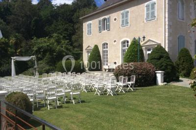 Escalier en pierre décoré de fleurs, menant à une pièce lumineuse avec carrelage en damier et vue sur un jardin.