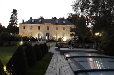 Escalier en pierre décoré de fleurs, menant à une pièce lumineuse avec carrelage en damier et vue sur un jardin.