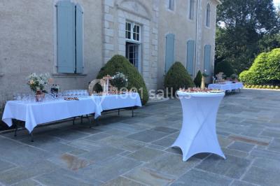 Escalier en pierre décoré de fleurs, menant à une pièce lumineuse avec carrelage en damier et vue sur un jardin.