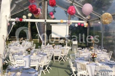 Escalier en pierre décoré de fleurs, menant à une pièce lumineuse avec carrelage en damier et vue sur un jardin.