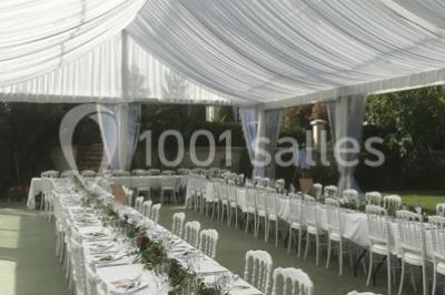 Escalier en pierre décoré de fleurs, menant à une pièce lumineuse avec carrelage en damier et vue sur un jardin.