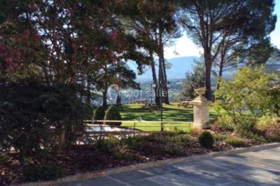Escalier en pierre décoré de fleurs, menant à une pièce lumineuse avec carrelage en damier et vue sur un jardin.