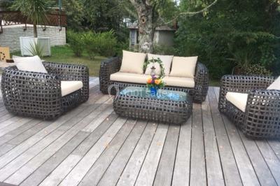 Escalier en pierre décoré de fleurs, menant à une pièce lumineuse avec carrelage en damier et vue sur un jardin.