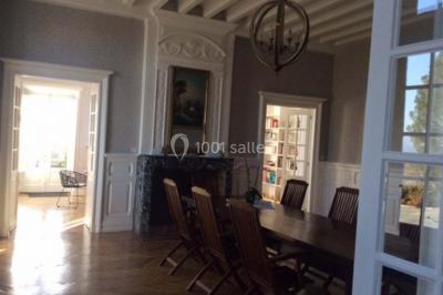 Escalier en pierre décoré de fleurs, menant à une pièce lumineuse avec carrelage en damier et vue sur un jardin.