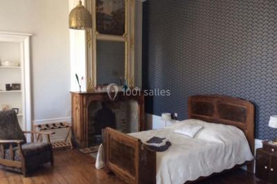 Escalier en pierre décoré de fleurs, menant à une pièce lumineuse avec carrelage en damier et vue sur un jardin.