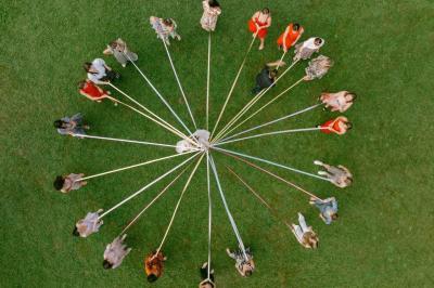 Escalier en pierre décoré de fleurs, menant à une pièce lumineuse avec carrelage en damier et vue sur un jardin.