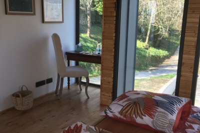 Piscine extérieure en bois devant une grande maison ancienne entourée d'un jardin arboré.
