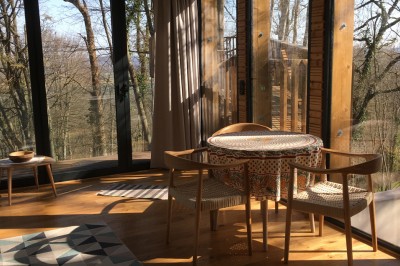 Piscine extérieure en bois devant une grande maison ancienne entourée d'un jardin arboré.