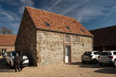 Chemin de campagne bordé de poteaux électriques et clôtures, traversant un paysage rural sous un ciel sombre.