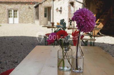 Chemin de campagne bordé de poteaux électriques et clôtures, traversant un paysage rural sous un ciel sombre.