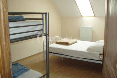 Chemin de campagne bordé de poteaux électriques et clôtures, traversant un paysage rural sous un ciel sombre.