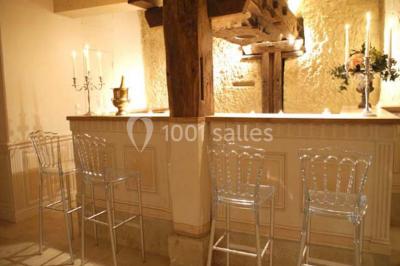 Miniature Location salle Tours (Indre-et-Loire) - La Grotte de la Roche aux Fées #8 Salle décorée dans une grotte avec des tables dressées, chandeliers rouges, plantes vertes et fleurs blanches et rouges.