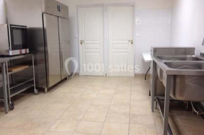 Miniature Location salle Tours (Indre-et-Loire) - La Grotte de la Roche aux Fées #13 Salle décorée dans une grotte avec des tables dressées, chandeliers rouges, plantes vertes et fleurs blanches et rouges.