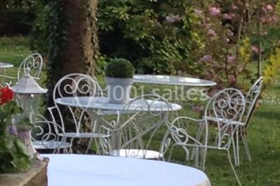 Miniature Location salle Tours (Indre-et-Loire) - La Grotte de la Roche aux Fées #14 Salle décorée dans une grotte avec des tables dressées, chandeliers rouges, plantes vertes et fleurs blanches et rouges.