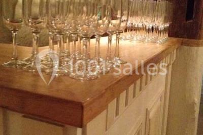 Miniature Location salle Tours (Indre-et-Loire) - La Grotte de la Roche aux Fées #20 Salle décorée dans une grotte avec des tables dressées, chandeliers rouges, plantes vertes et fleurs blanches et rouges.