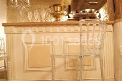 Miniature Location salle Tours (Indre-et-Loire) - La Grotte de la Roche aux Fées #21 Salle décorée dans une grotte avec des tables dressées, chandeliers rouges, plantes vertes et fleurs blanches et rouges.