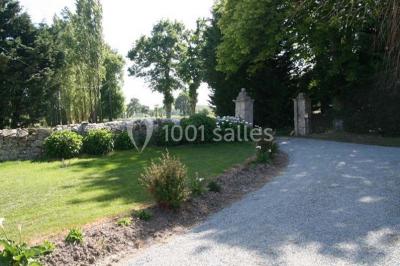 Lit double avec une parure à motifs végétaux verts et blancs, encadré par deux tables de chevet avec lampes allumées.