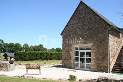 Lit double avec une parure à motifs végétaux verts et blancs, encadré par deux tables de chevet avec lampes allumées.