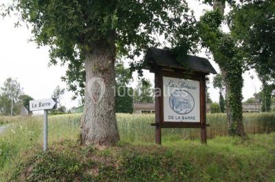 Lit double avec une parure à motifs végétaux verts et blancs, encadré par deux tables de chevet avec lampes allumées.