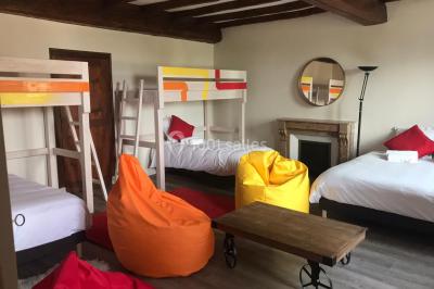 Allée bordée d'arbres et d'arbustes, avec un sol en gravier sous un ciel bleu dégagé.