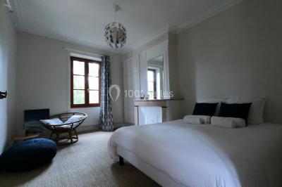 Allée bordée d'arbres et d'arbustes, avec un sol en gravier sous un ciel bleu dégagé.