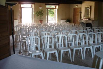 Allée bordée d'arbres et d'arbustes, avec un sol en gravier sous un ciel bleu dégagé.