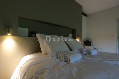 Allée bordée d'arbres et d'arbustes, avec un sol en gravier sous un ciel bleu dégagé.