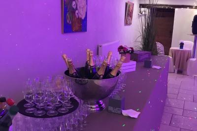 Allée bordée d'arbres et d'arbustes, avec un sol en gravier sous un ciel bleu dégagé.