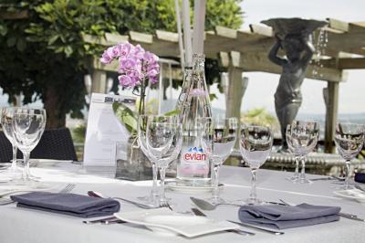 Deux personnes jouent au mini-golf sur un terrain entouré de végétation, avec une cabane perchée visible en arrière-plan.