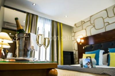 Deux personnes jouent au mini-golf sur un terrain entouré de végétation, avec une cabane perchée visible en arrière-plan.