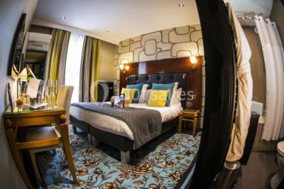 Deux personnes jouent au mini-golf sur un terrain entouré de végétation, avec une cabane perchée visible en arrière-plan.