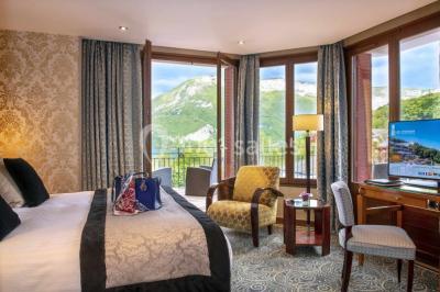 Deux personnes jouent au mini-golf sur un terrain entouré de végétation, avec une cabane perchée visible en arrière-plan.