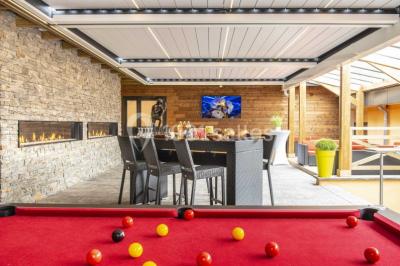 Deux personnes jouent au mini-golf sur un terrain entouré de végétation, avec une cabane perchée visible en arrière-plan.