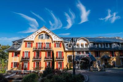 Deux personnes jouent au mini-golf sur un terrain entouré de végétation, avec une cabane perchée visible en arrière-plan.