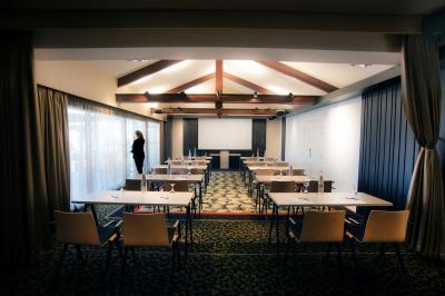 Deux personnes jouent au mini-golf sur un terrain entouré de végétation, avec une cabane perchée visible en arrière-plan.