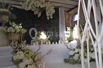 Cheminée ancienne en pierre avec un bas-relief sculpté, encadrée par un mur bleu et un plafond en bois.