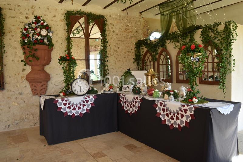 Décoration de table sur le thème d'Alice au Pays des Merveilles avec horloges, vaisselle et éléments végétaux.