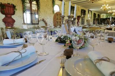 Cheminée ancienne en pierre avec un bas-relief sculpté, encadrée par un mur bleu et un plafond en bois.