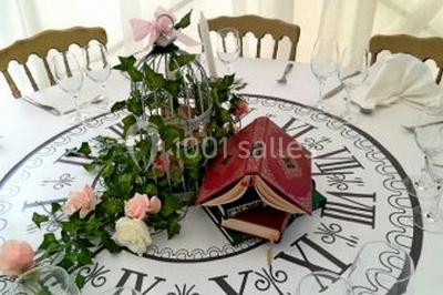 Cheminée ancienne en pierre avec un bas-relief sculpté, encadrée par un mur bleu et un plafond en bois.