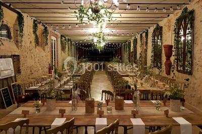 Cheminée ancienne en pierre avec un bas-relief sculpté, encadrée par un mur bleu et un plafond en bois.