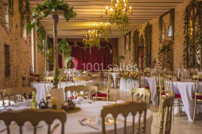 Cheminée ancienne en pierre avec un bas-relief sculpté, encadrée par un mur bleu et un plafond en bois.