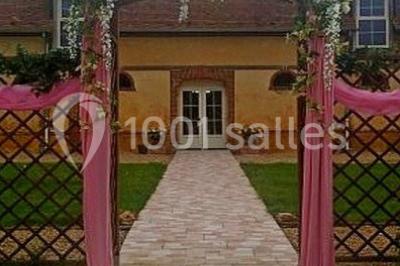 Cheminée ancienne en pierre avec un bas-relief sculpté, encadrée par un mur bleu et un plafond en bois.