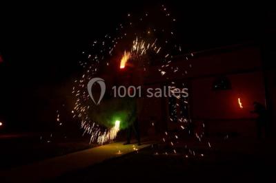Cheminée ancienne en pierre avec un bas-relief sculpté, encadrée par un mur bleu et un plafond en bois.