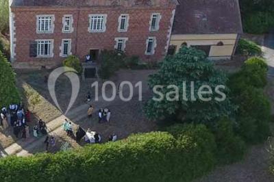Cheminée ancienne en pierre avec un bas-relief sculpté, encadrée par un mur bleu et un plafond en bois.
