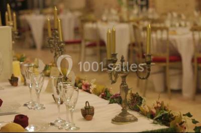 Cheminée ancienne en pierre avec un bas-relief sculpté, encadrée par un mur bleu et un plafond en bois.