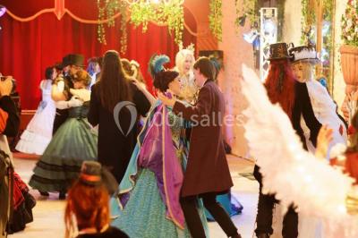 Cheminée ancienne en pierre avec un bas-relief sculpté, encadrée par un mur bleu et un plafond en bois.